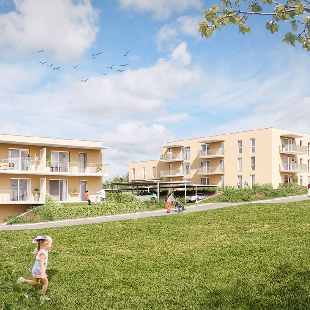 Mehrgeschoßiger Wohnbau mit Balkonen, im Vordergrund leicht ansteigender Spazierweg und große Wiese